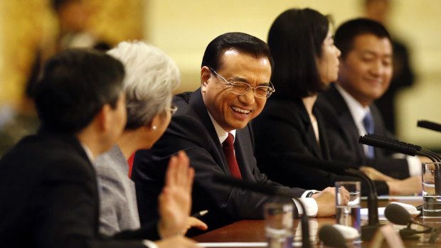 Chinese Premier Li Keqiang, centre, laughs during the international press conference.