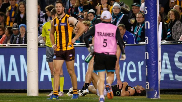 Chad Wingard lies injured after the clash.