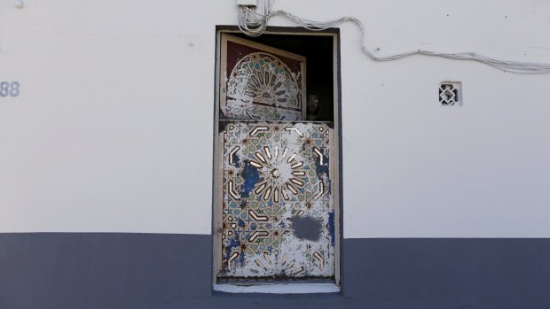 A man closes a window of a mosque in El Saladillo in Algeciras town, Spain, where the gunman is reported to have lived.
