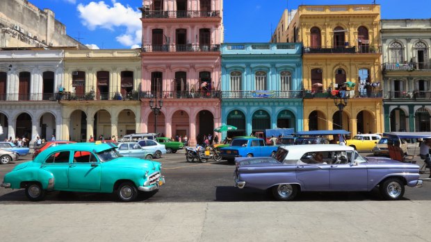 Vintage American cars, imported prior to the trade embargo, moving on the streets of colourful Havana, Cuba. 