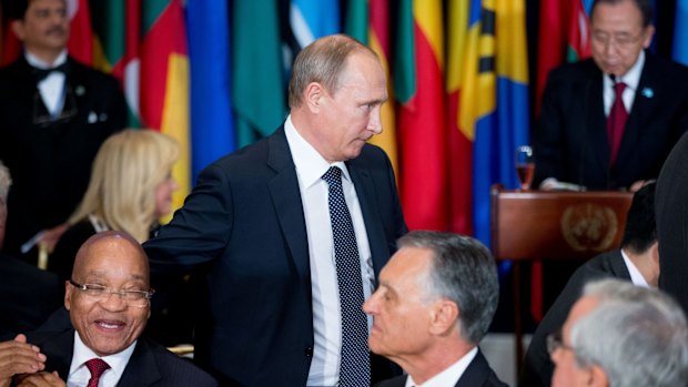 Russian President Vladimir Putin arrives for a lunch hosted by United Nations Secretary-General Ban Ki-moon, right, on Monday.