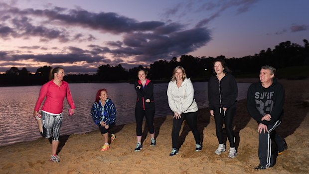 Personal trainer Diane Lindner, left, stretches with her clients at Lilydale Lake.