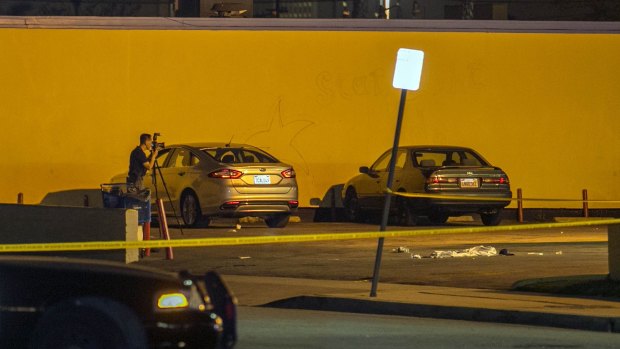 A Los Angeles County Sheriff's Department investigator photographs the scene of an accident at a parking lot. 