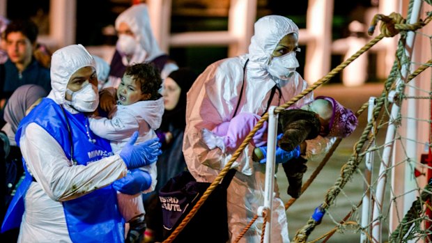 Children rescued from a boat in the Sicilian Strait are taken ashore at Pozzallo in Italy on Monday. 