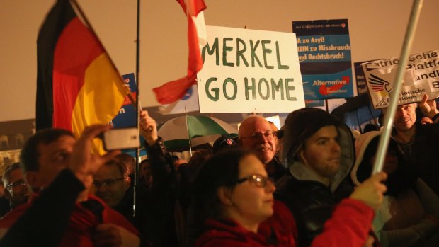 Supporters of the AfD political party protest against German Chancellor Angela Merkel's liberal policy towards taking in migrants and refugees on October 14. 