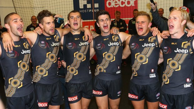 Richmond players sing the club song in the rooms after defeating Essendon in the Dreamtime at the G game on Saturday.