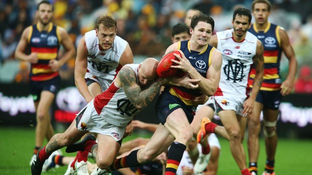 Adelaide's Patrick Dangerfield is tackled by Nathan Jones of the Demons on Saturday.