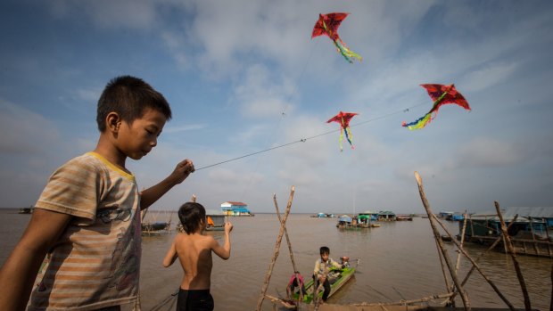 Children fly kites in the floating village.