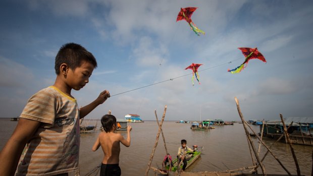 Children fly kites in the floating village.