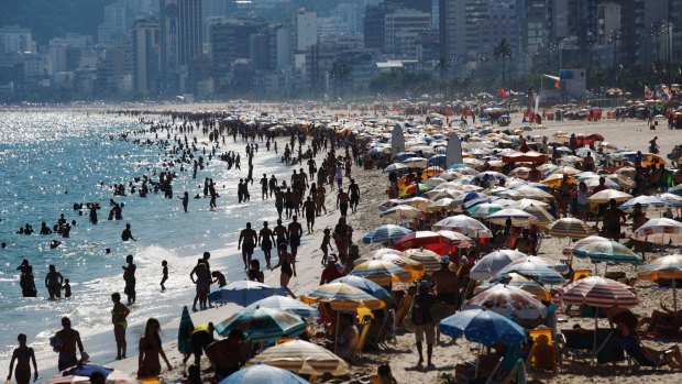 People gather on Ipanema beach, a landmark tourist destination in Rio. 