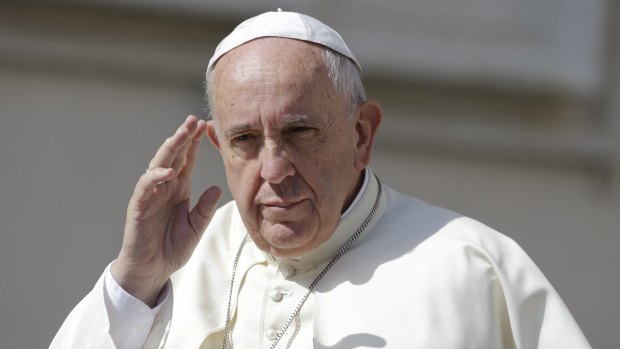 Taking stand on climate change: Pope Francis waves as he arrives for his weekly general audience, in St Peter's Square at the Vatican.