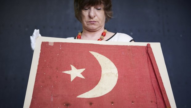Mining & Minerals Museum manager Angela Bailey with the home-made Turkish flag wielded by two Afghan jihadists in 1915.