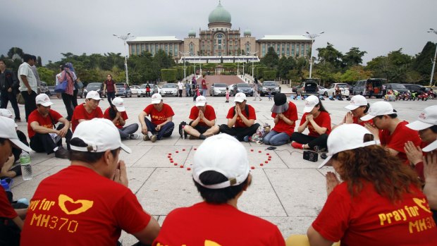 Chinese family members of MH370 passengers pray outside the prime minister's office in Putrajaya, Malaysia last week. 