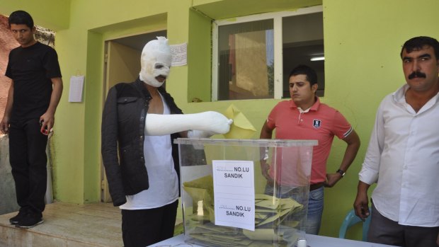 Wounded in Saturday's attack against the pro-Kurdish Peoples' Democratic Party (HDP) rally in Diyarbakir, a Turk casts his ballot on Sunday.