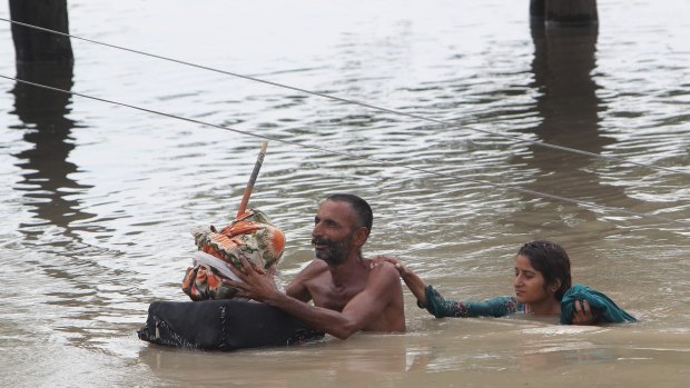 Villagers wade through floodwaters in Rajanpur, Pakistan, on Thursday.
