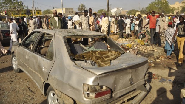 People gather at the site of a bomb explosion in Kano, Nigeria, in November 2014, in a region terrorised by Boko Haram.