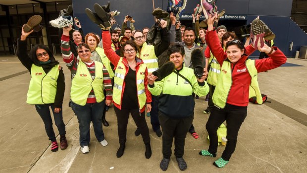 National Union of Workers members take off their boots in solidarity with women AFL players at Etihad Stadium.