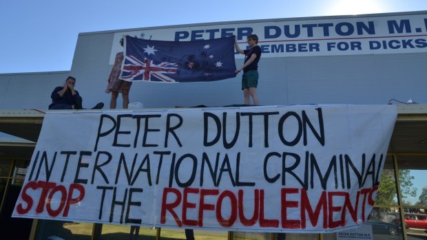 Protesters climbed onto the awning of Immigration Minister Peter Dutton's office to denounce the government's new immigration policy.