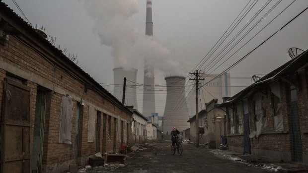 Riding a bike near a coal fired power plant on the outskirts of Beijing earlier this week. 
