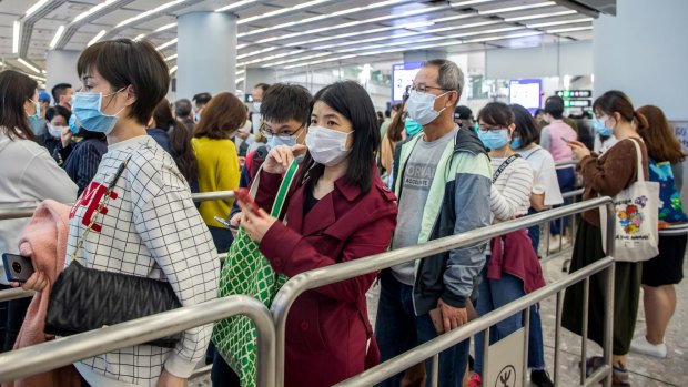 Travellers wear face masks at a train station in Hong Kong.