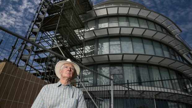 Owners Corporation Network ACT president Gary Petherbridge in front of scaffolding for repair work on a block of apartments at the Kingston Foreshore.