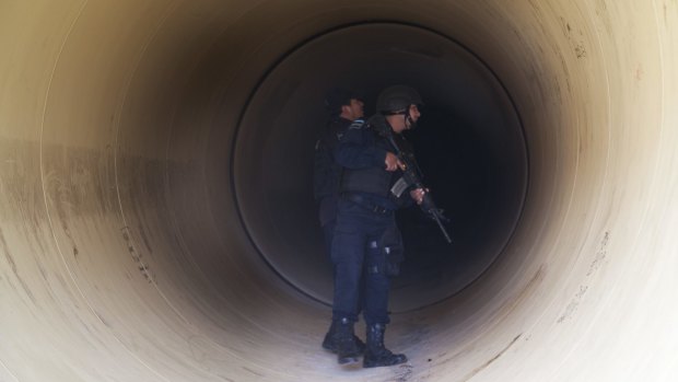 Federal police inspect a drainage pipe outside the Altiplano maximum security prison in Almoloya, west of Mexico City on Sunday.