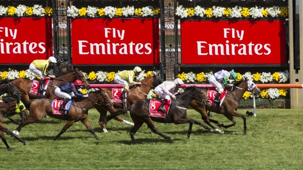 The horses come around the first bend in the 2015 Melbourne Cup at Flemington. 