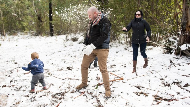 James, 1, Owen and Annelie Duffell from Adelaide enjoy the snow at Tidbinbilla.