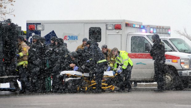 Emergency personnel transport an officer to an ambulance after reports of a shooting near the Planned Parenthood in Colorado Springs.