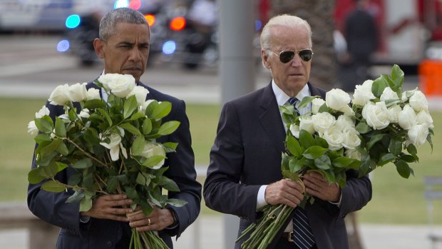 President Barack Obama with Vice President Joe Biden carry bouquets of 49 white roses in total, at a memorial to the 49 victims of the Pulse nightclub shooting.