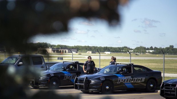 Burton Police Officers gather at Bishop International Airport, Wednesday morning in Flint, Michigan.