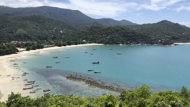 Fishing vessels and boats used to ferry tourists sit idle along a deserted beach on the popular tourist island of Koh Phangan, Thailand.