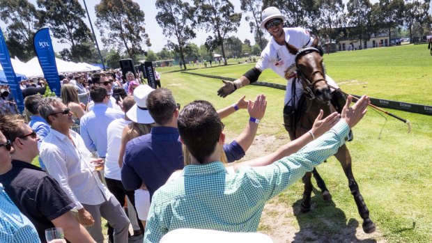 A Stella Artois player greets spectators after Saturday's Polo In The City match in Albert Park. 
