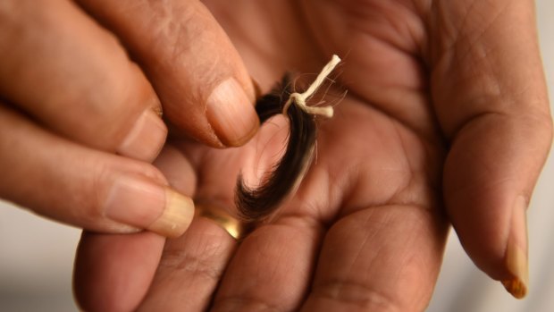 Reginald Mullaly's sister Dawn holds a lock of his hair.