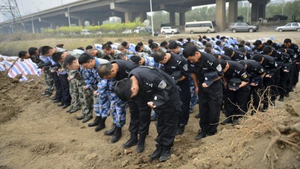 Representatives from the police and People's Liberation Army (PLA), marking the seventh day since the Tianjin explosions, pay tribute to the people who died, in a ceremony at Binhai new district, Tianjin.