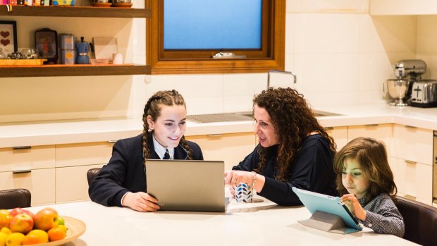 Cathy Filardo is seen helping her children, 13-year-old Siena and 5-year-old Massimo with their homework at home in Melbourne.