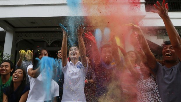 Actress Lovi Poe, fourth from left, sister of Presidential candidate Grace Poe leads the symbolic throwing of coloured powder as her sister is endorsed by a minor party campaigning for a seat the Lower House.
