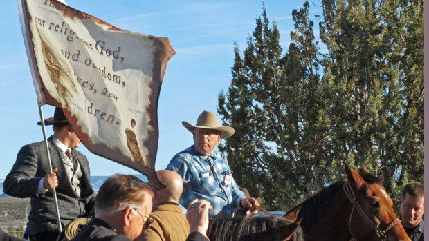 Cliven Bundy, on horseback at centre, joins the funeral procession for Arizona rancher Robert LaVoy Finicum in Kanab, Utah in February.