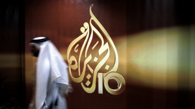 An employee walks past the logo of Al Jazeera in Doha. Among the 13 demands is the closure of the Qatar-funded network.