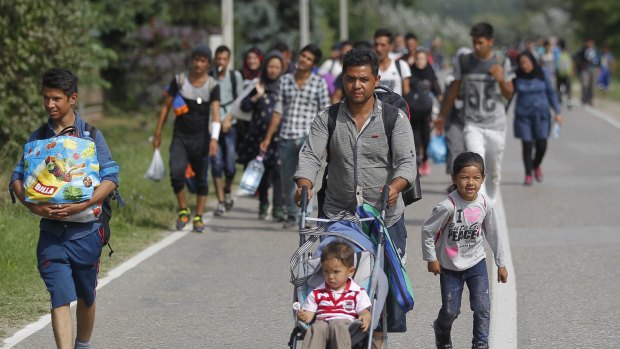 Migrants walk down the motorway toward buses which will take them to Croatia at the Horgos border crossing with Hungary in Serbia.