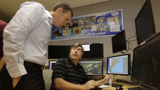 Jack Beven, senior hurricane specialist, right, talks with storm surge specialist Jamie Rhome, left, at the National Hurricane Center. 