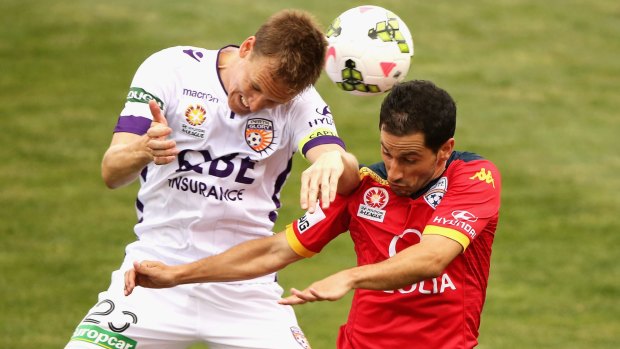 STALEMATE: Michael Thwaite of Perth Glory competes for the ball with Sergio Cirio of Adelaide United.