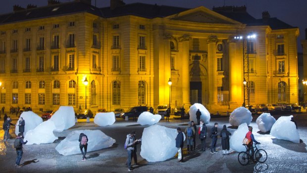 Visitors walk through ice blocks as part of the sculpture Ice Watch, by Danish artist Olafur Eliasson, as part of the Paris climate talks. 