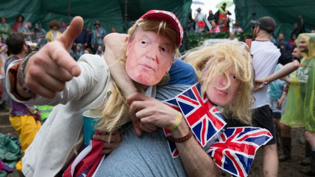 Men dressed as Boris Johnson and Donald Trump prepare to take part in a tomato fight at Britain's Glastonbury Festival.