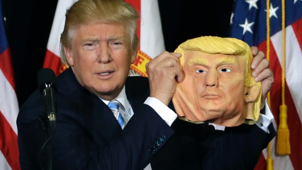 Republican presidential candidate Donald Trump holds up a Donald Trump mask during a campaign speech on Monday.