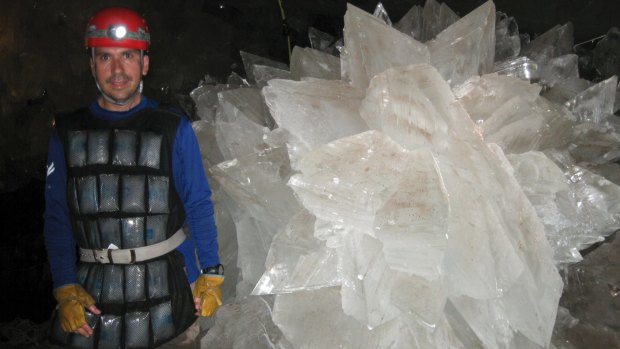 Mario Corsalini stands near a gypsum rosette crystal in the Naica cave system, where scientists have discovered life trapped in crystals that could be 50,000 years old.  