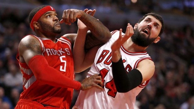 Battling for position: Houston Rockets forward Josh Smith blocks out Chicago Bulls rookie Nikola Mirotic as they wait for a rebound in Chicago.