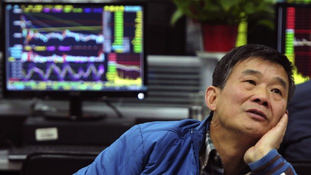 A man looks at stock prices at a brokerage house in Jiujiang in China.
