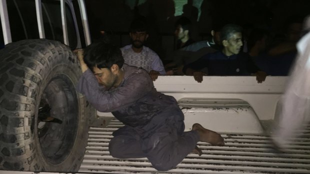 A wounded man rests on a vehicle after a suicide attack on a mosque in Herat, Afghanistan.