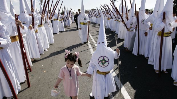 Penitents of "San Gonzalo" brotherhood participate in a Holy Week procession in Seville, southern Spain. Hundreds of processions take place throughout Spain during Easter week.